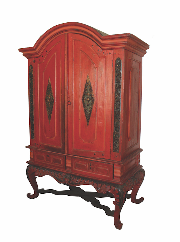 A red colonial wooden cabinet with two doors