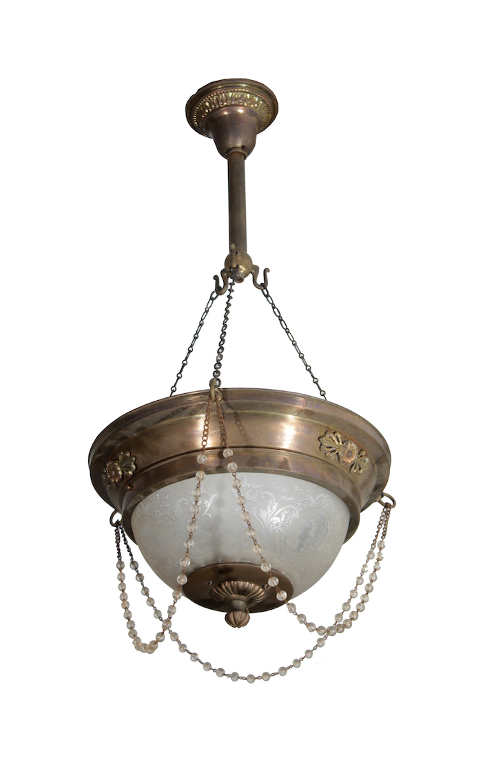 A brass hanging lamp with white glass