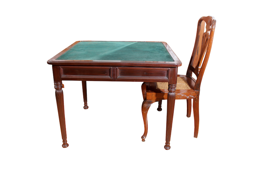 A carved wooden table with four legs anda wooden chair with rattan seat