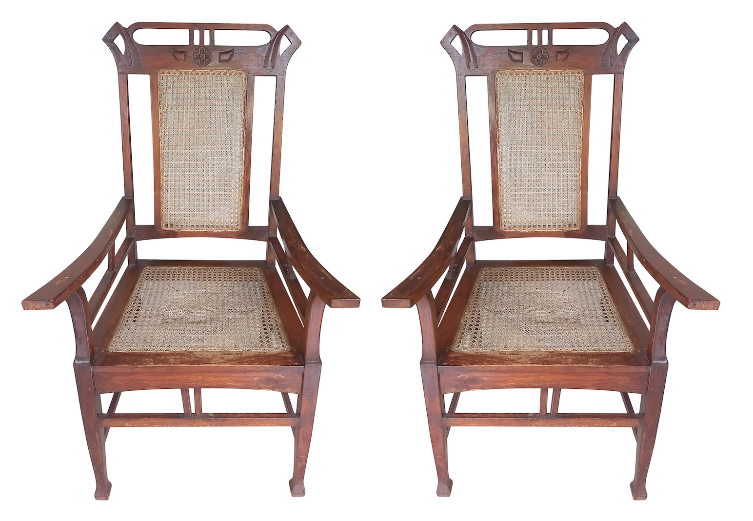 A pair of carved teak art nouveau arm chairs with rattan seat and back