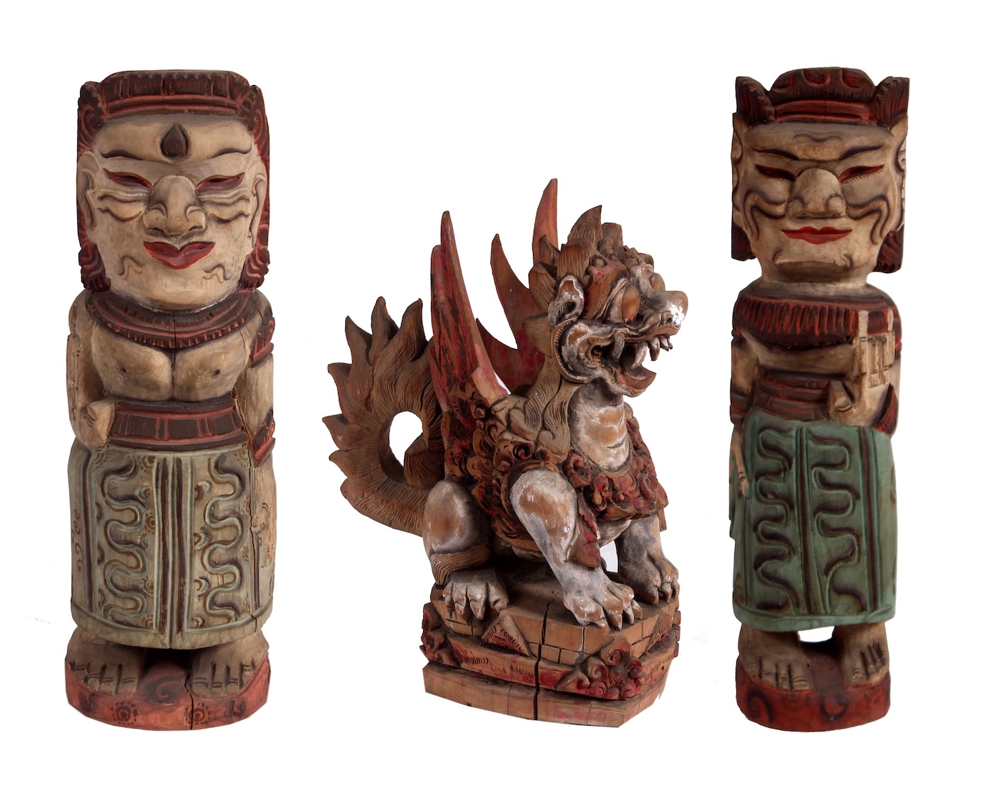 A set of three Balinese statues consisting of a carved wood in form of guardian chimera ( winged lion) and a pair of carved wood standing figures