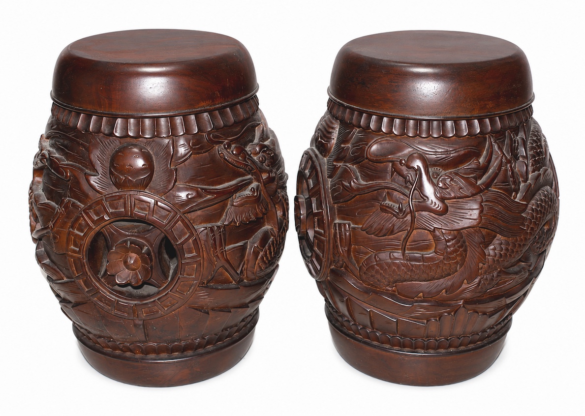 A pair of modern carved teak stools